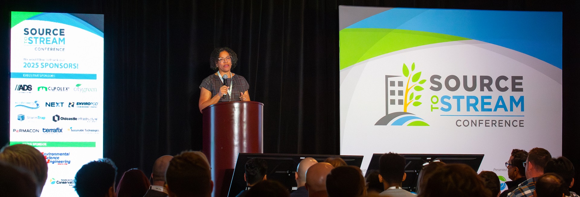 a presenter addresses delegates at the Source to Stream Conference